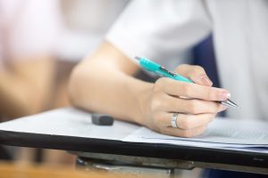 Soft,Focus.high,School,Or,University,Student,Holding,Pencil,Writing,On