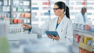 Pharmacy,Drugstore:,Beautiful,Caucasian,Pharmacist,Uses,Digital,Tablet,Computer,,Checks